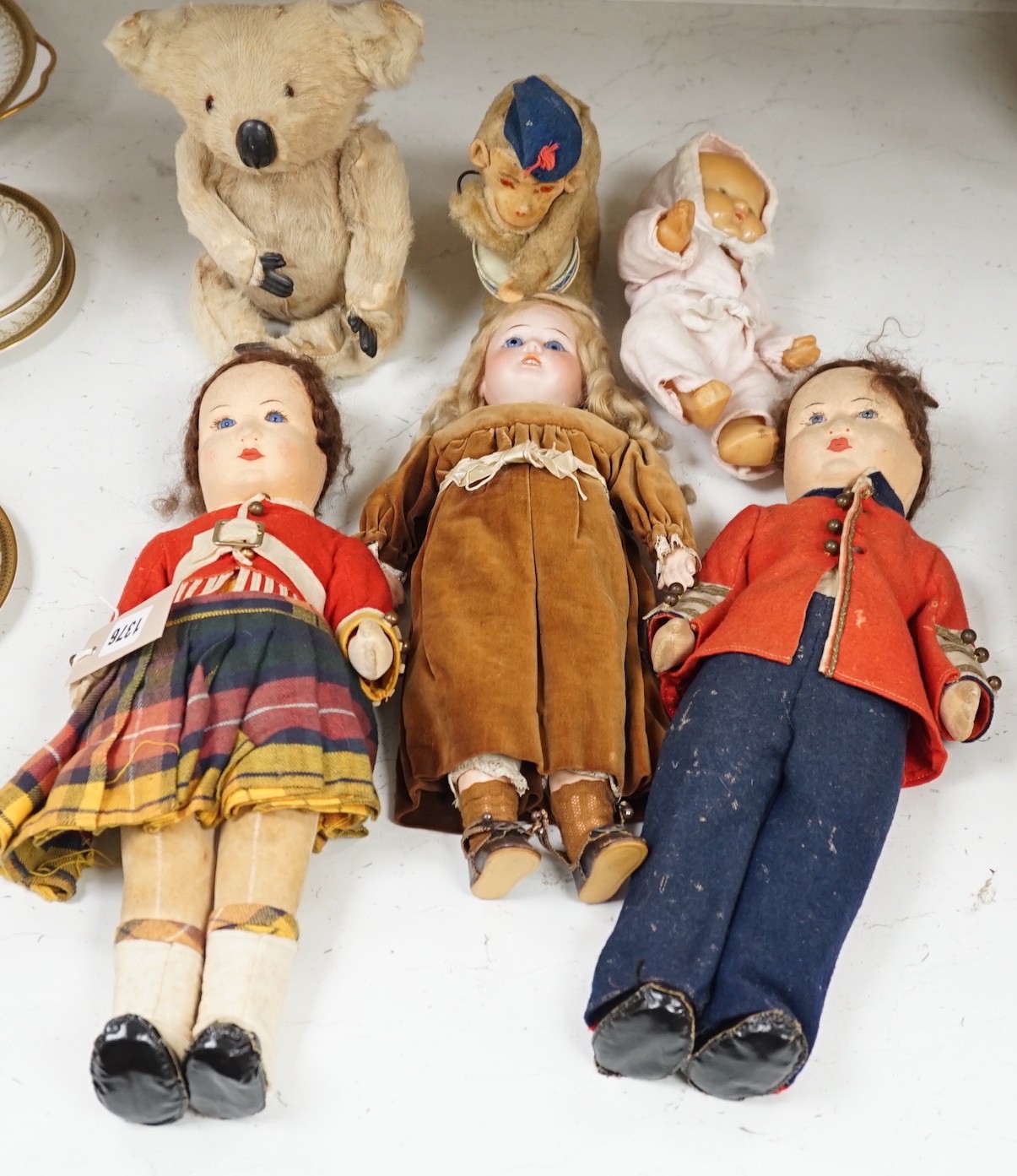 Two Chad Valley felt soldier dolls with glass eyes, a German bisque head doll, a rubber doll and a wind up monkey